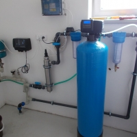 úpravna vody v rodinném domě -  zleva tlaková nádoba, řídící jednotka, UV lampa, trubní filtry, sklolaminátový automatický filtr